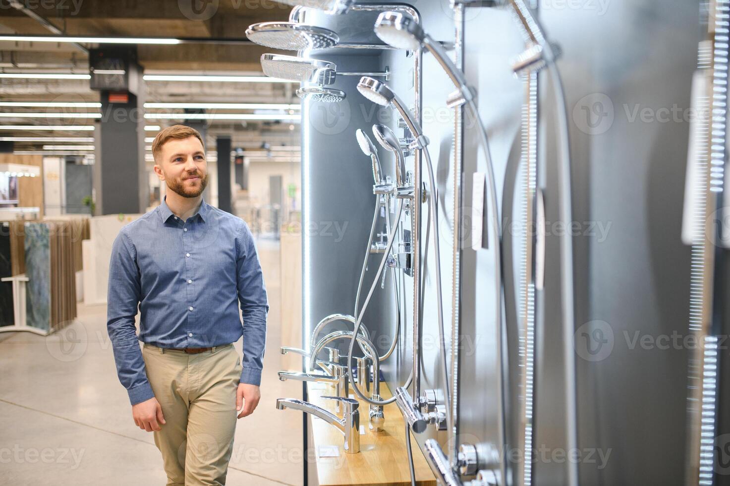 Selects a shower faucet. Man chooses a products in a sanitary ware store photo