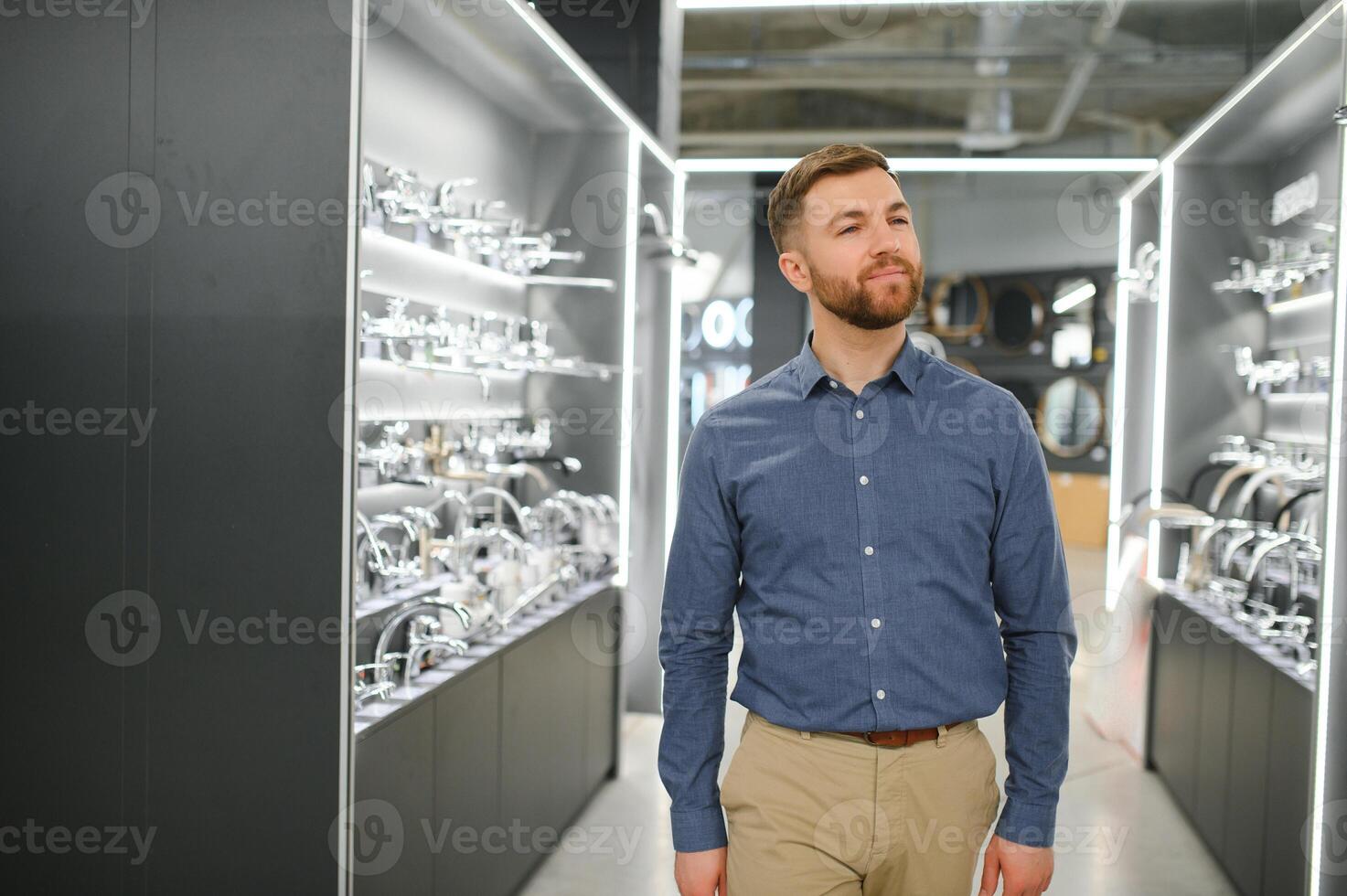 Playing with shower faucet. Man chooses a products in a sanitary ware store photo