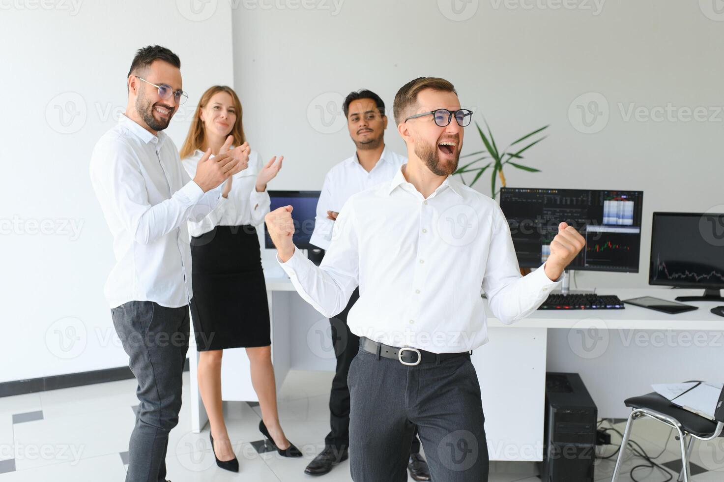 Team leader stands with coworkers in background photo