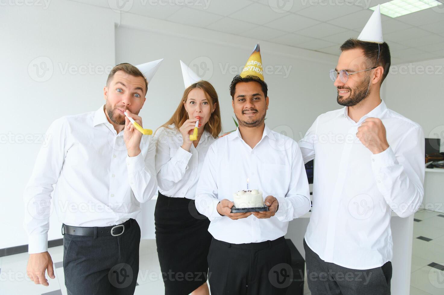 happy business team with birthday cake and gifts greeting indian male colleague at office party photo