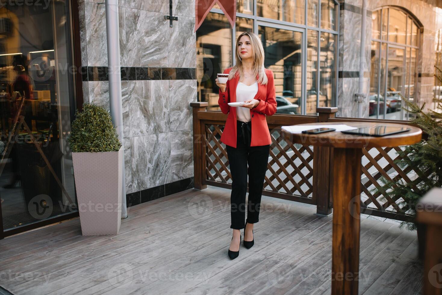 Outdoor city fashion portrait of young businesswoman working at cafe on terrace at sunny day, casual stylish outfit, mint details, using her tablet, cafe break, business concept photo