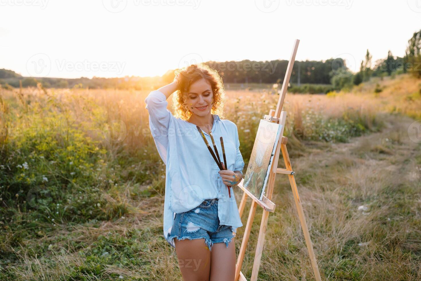 Pretty talented female painter painting on easel, making colorful sketches, creating marine landscape. Beautiful female artist painting with watercolor paints. Creativity and imagination concept photo