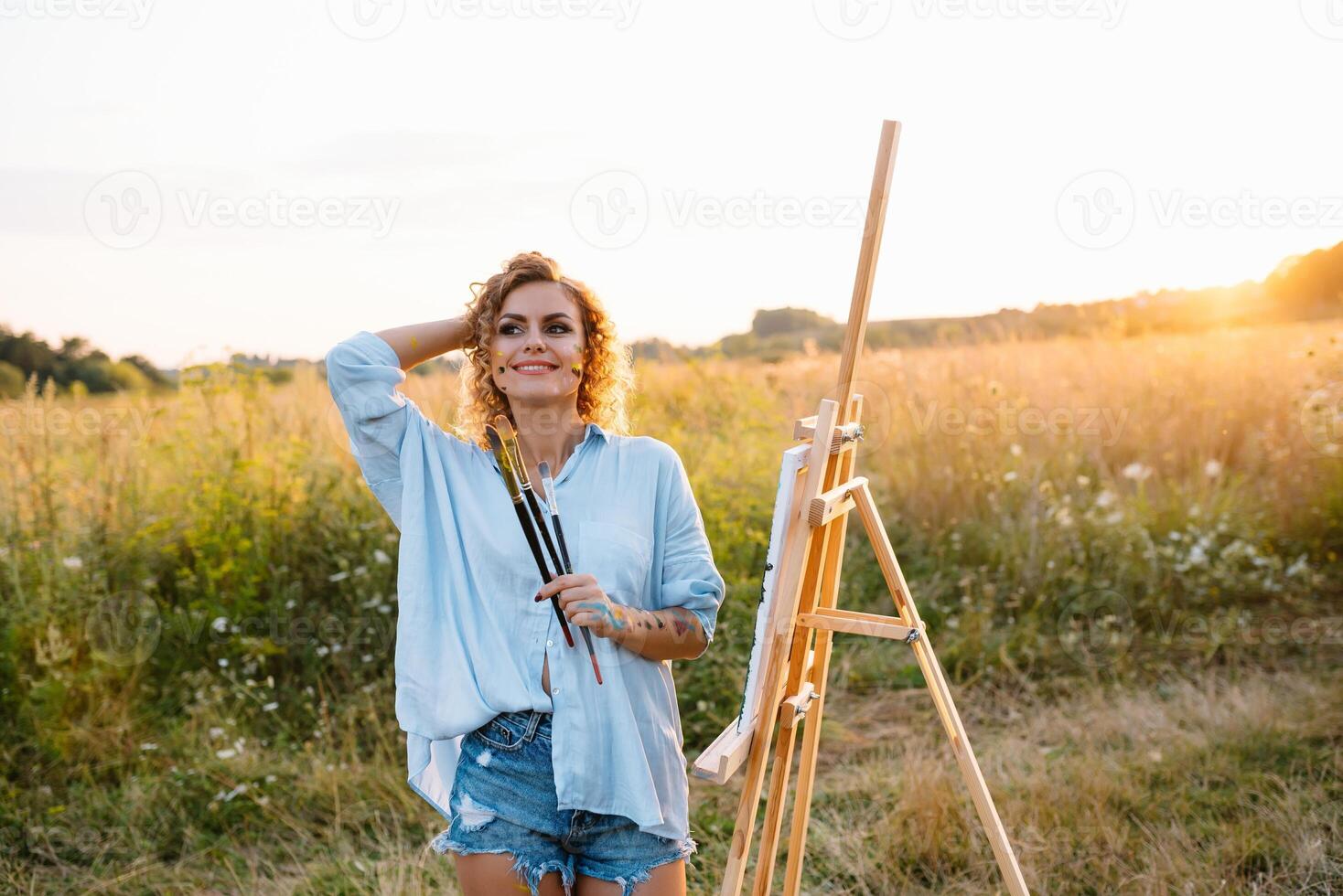 Pretty talented female painter painting on easel, making colorful sketches, creating marine landscape. Beautiful female artist painting with watercolor paints. Creativity and imagination concept photo