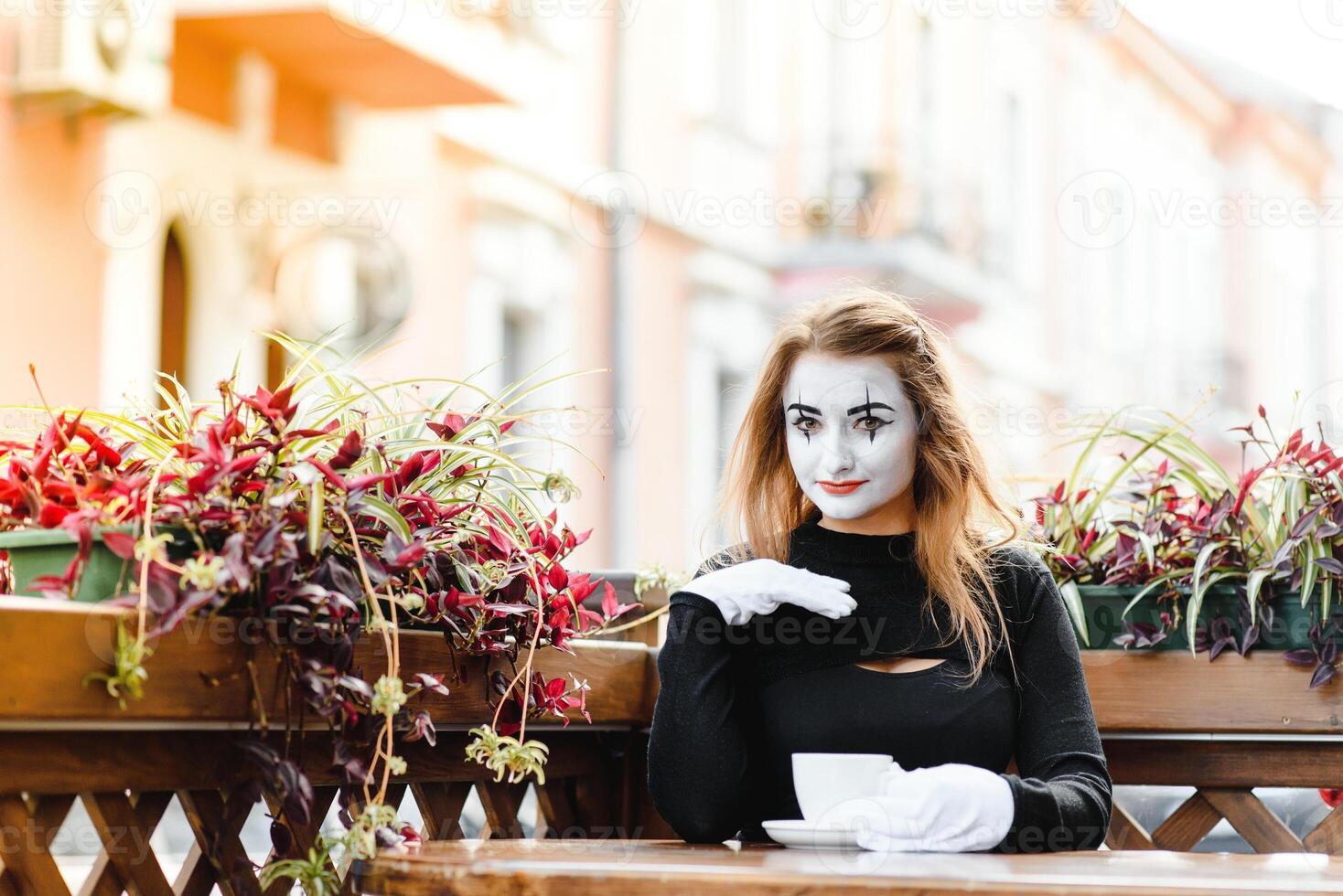 Mime comedian drinking coffee. girl mime drinks coffee in paris. photo