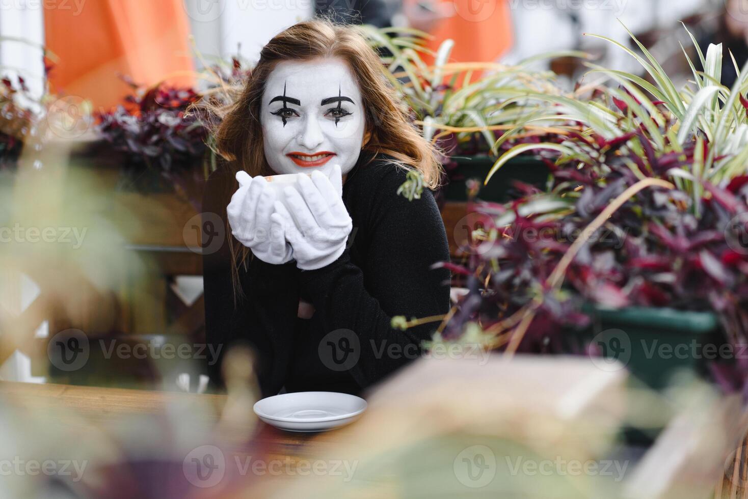 Mime comedian drinking coffee. girl mime drinks coffee in paris. photo
