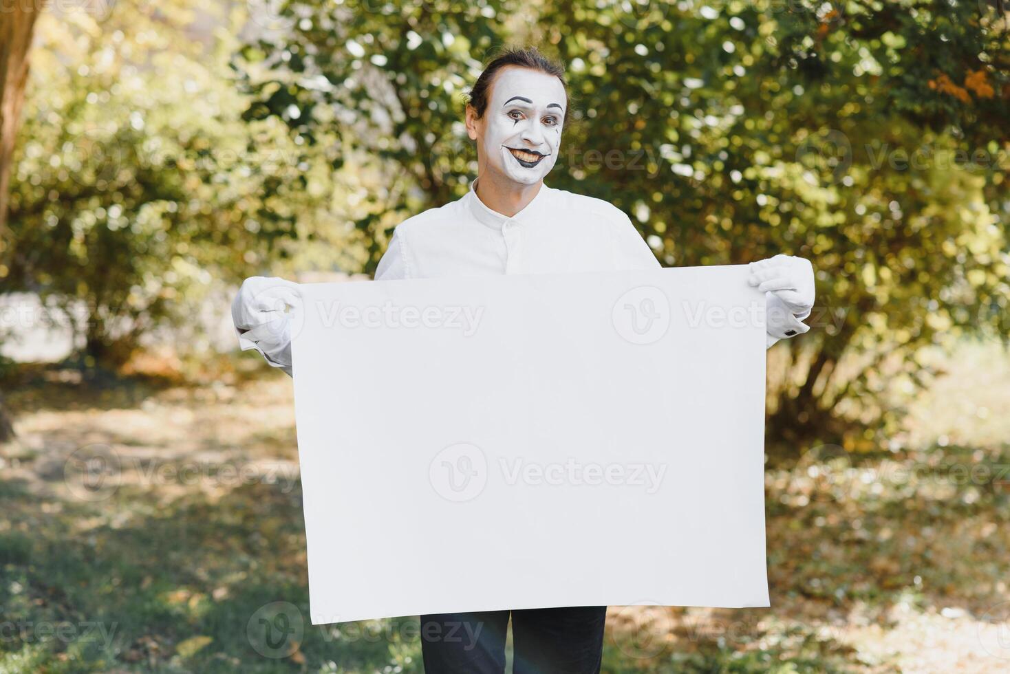 Your text here. Actors mimes holding empty white letter. Colorful portrait with green background. April fools day photo