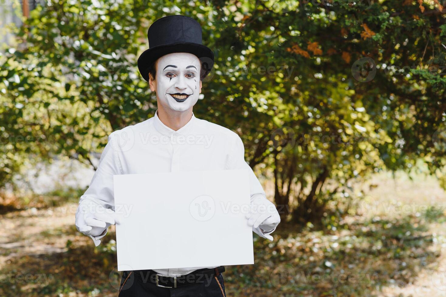 Your text here. Actors mimes holding empty white letter. Colorful portrait with green background. April fools day photo