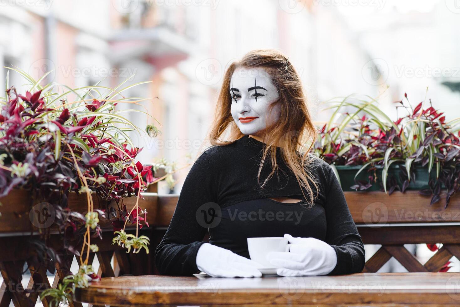 Mime comedian drinking coffee. girl mime drinks coffee in paris. photo