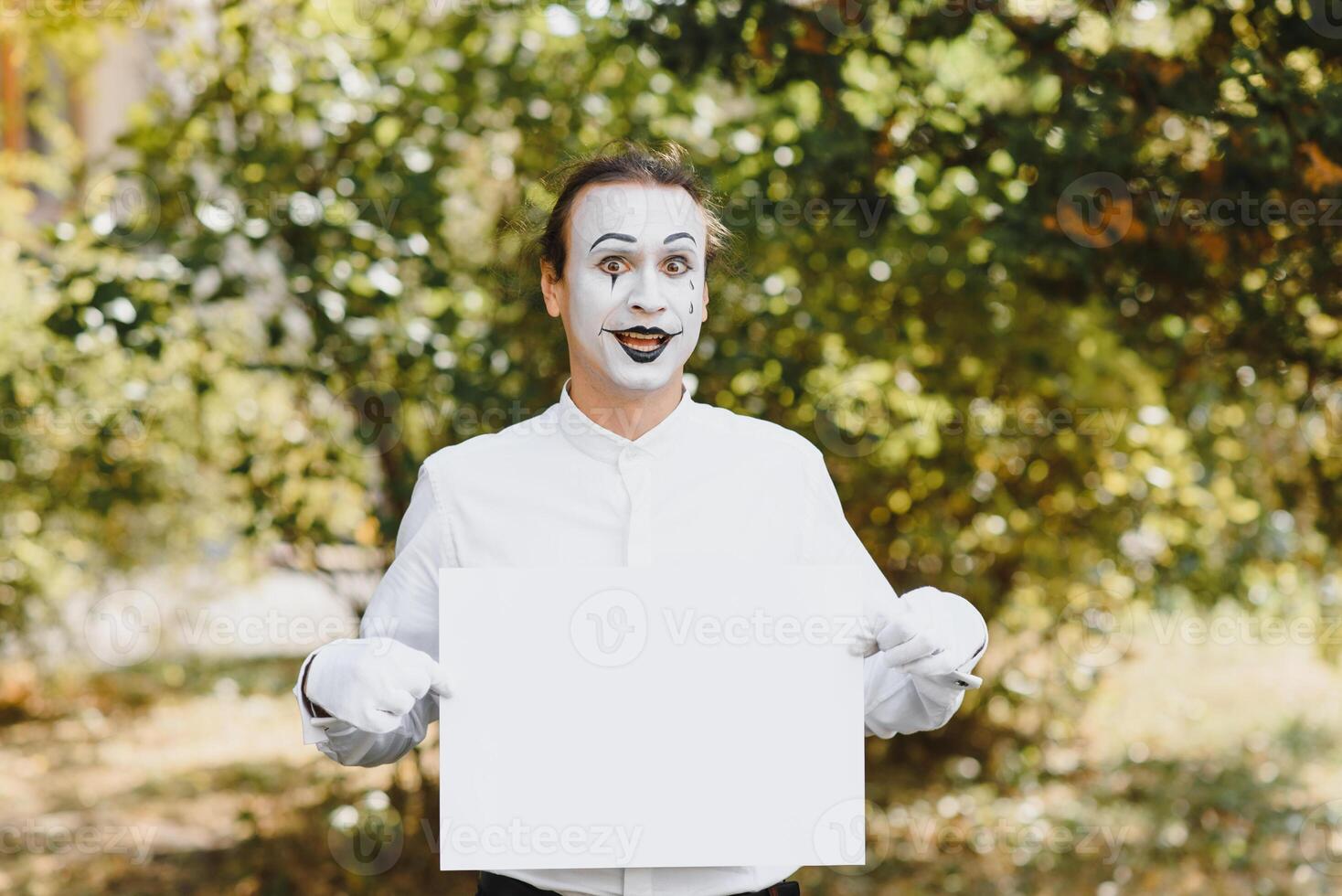 Your text here. Actors mimes holding empty white letter. Colorful portrait with green background. April fools day photo