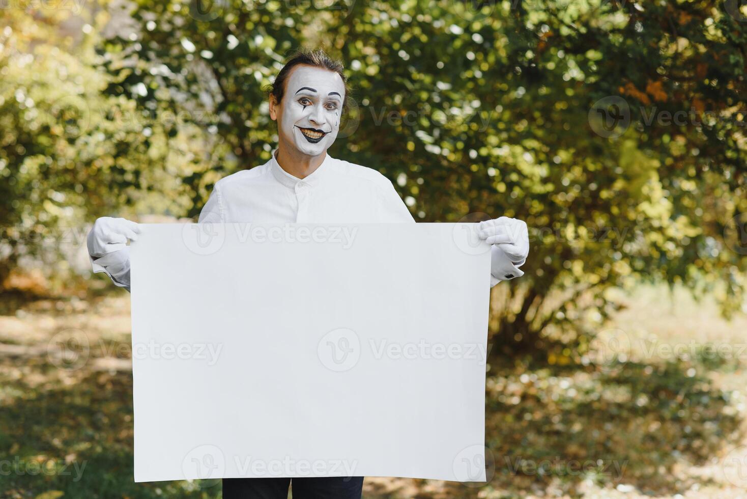Your text here. Actors mimes holding empty white letter. Colorful portrait with green background. April fools day photo