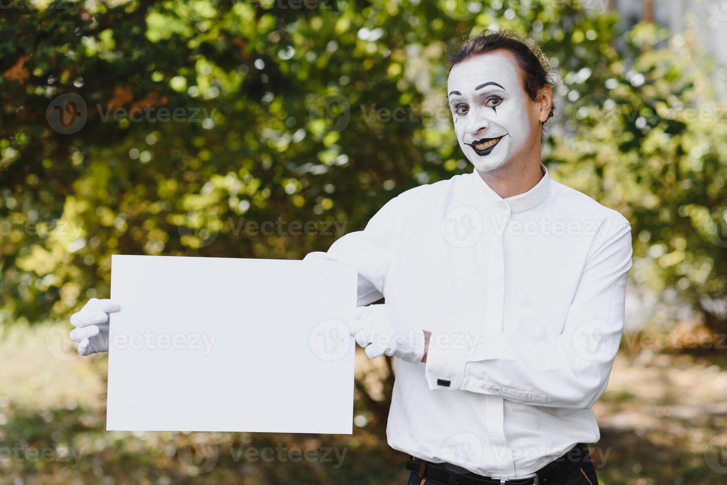Your text here. Actors mimes holding empty white letter. Colorful portrait with green background. April fools day photo