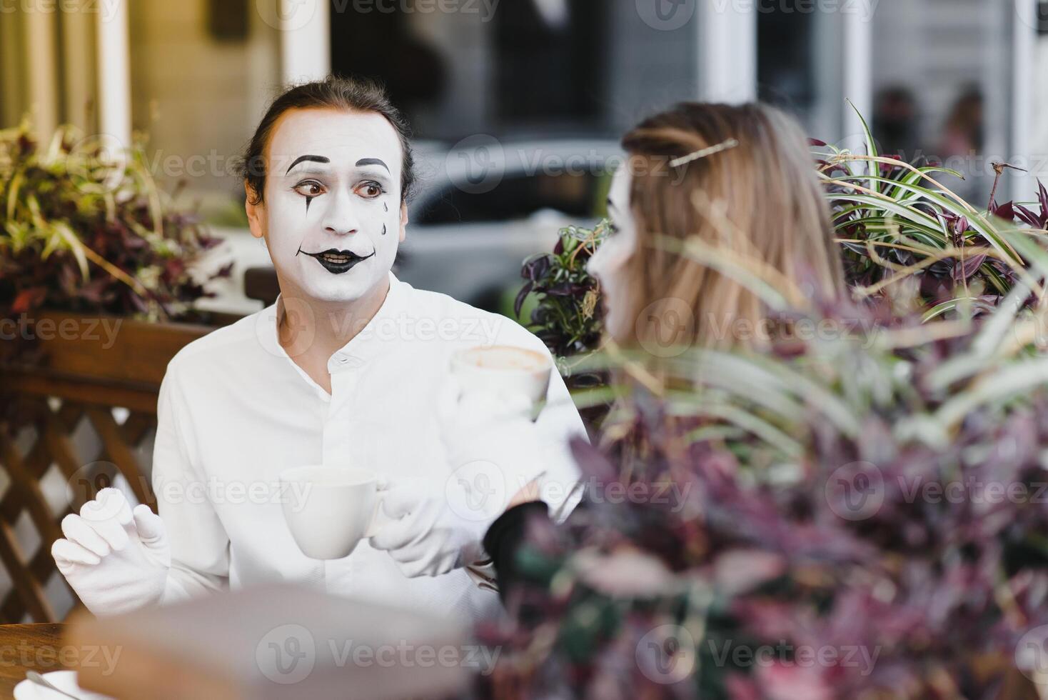 Mimes in front of Paris cafe acting like drinking tea or coffee. photo
