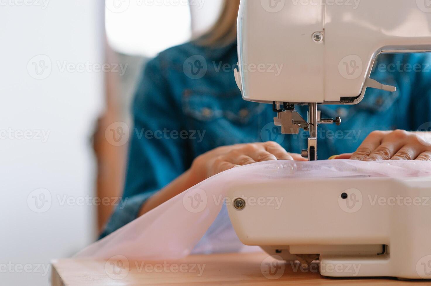 sewing machine, pink fabric and women's hands photo