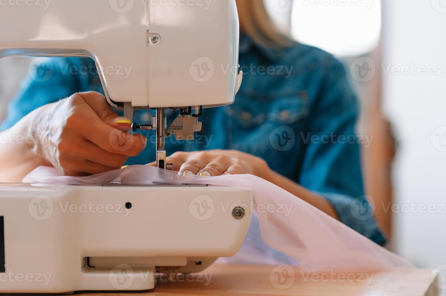 sewing machine, pink fabric and women's hands photo