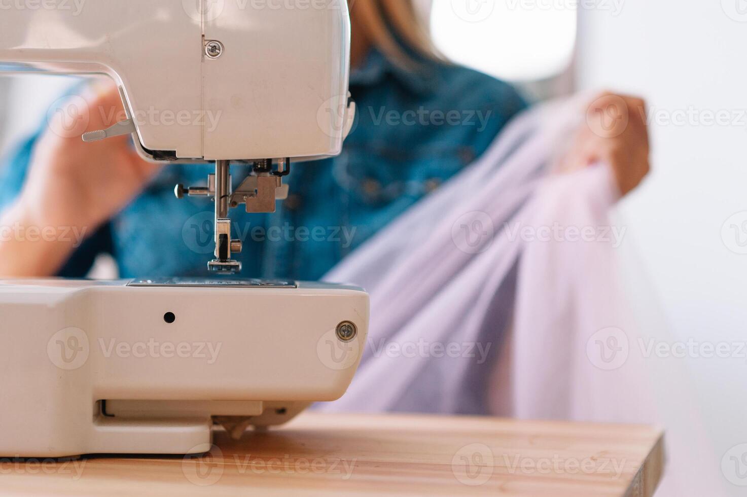 sewing machine, pink fabric and women's hands photo