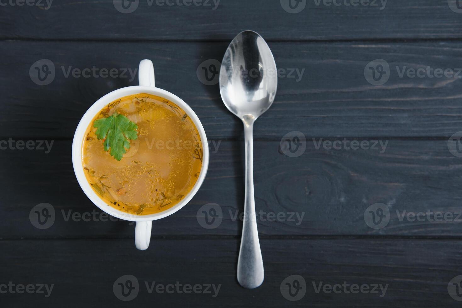 A picture of a bowl of traditional chicken soup served in a bowl over wooden background photo