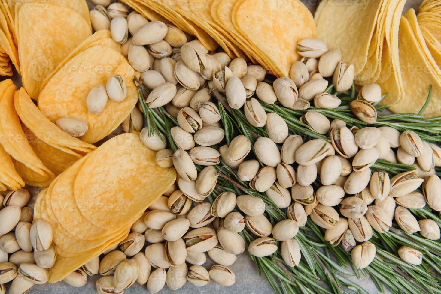 Beer snacks on craft paper. Assorted nuts and chips. Top view with copyspace black background photo