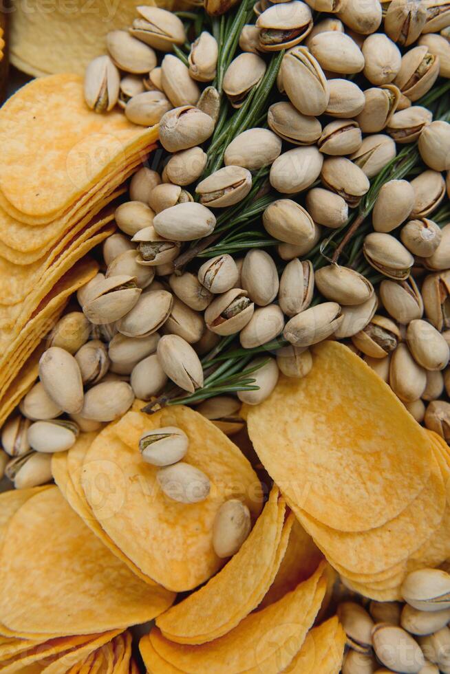 Beer snacks on craft paper. Assorted nuts and chips. Top view with copyspace black background photo