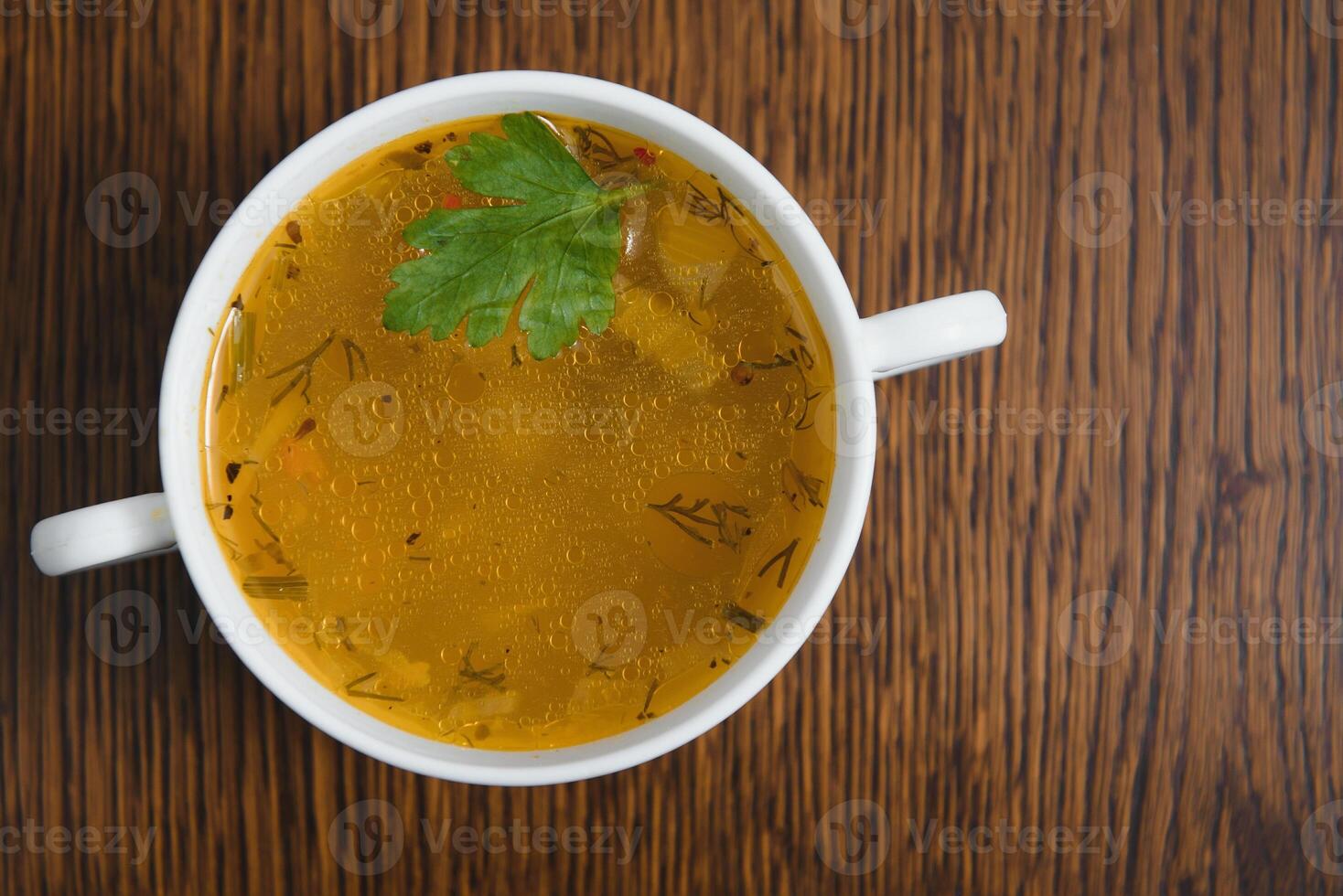 A picture of a bowl of traditional chicken soup served in a bowl over wooden background photo