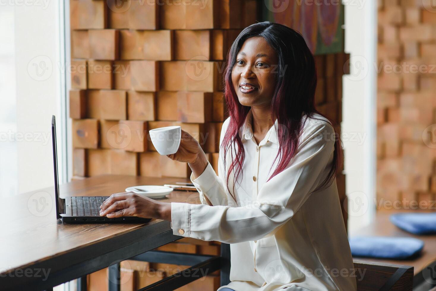 Happy african american woman worker using laptop work study at computer in loft office or cafe, smiling mixed race female student freelancer using pc app dating communicating online watching webinar photo