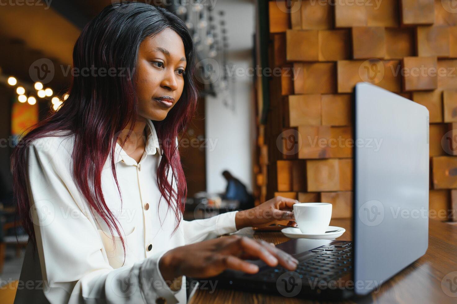 Happy african american woman worker using laptop work study at computer in loft office or cafe, smiling mixed race female student freelancer using pc app dating communicating online watching webinar photo