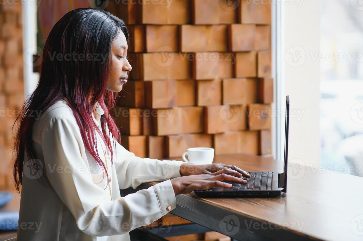 Happy african american woman worker using laptop work study at computer in loft office or cafe, smiling mixed race female student freelancer using pc app dating communicating online watching webinar photo