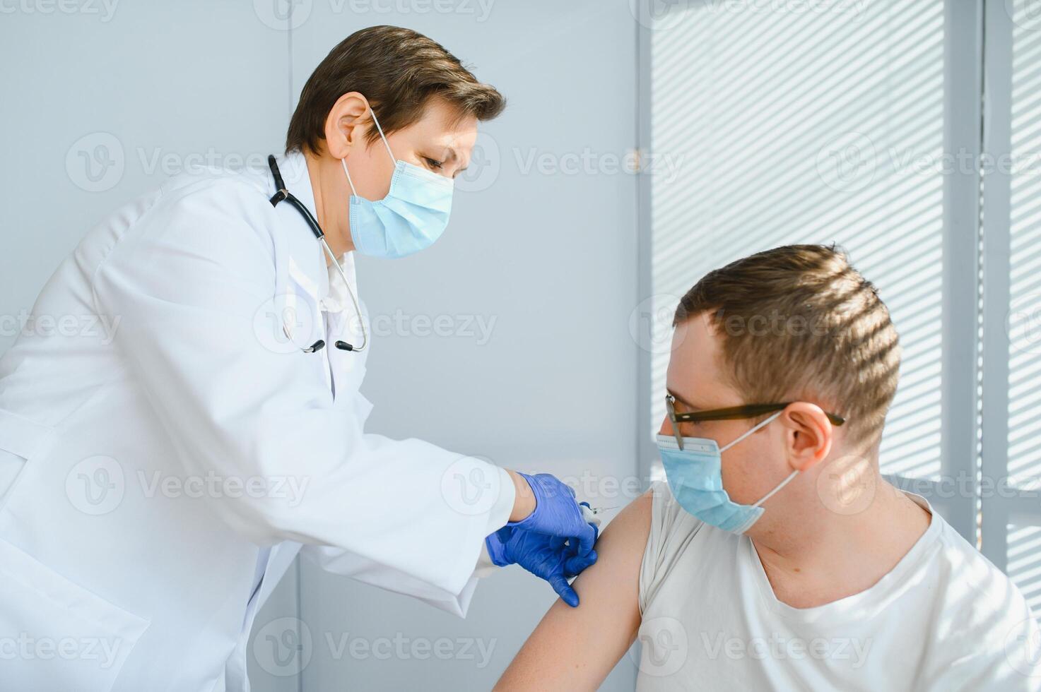 Close up of a Doctor making a vaccination in the shoulder of patient, Flu Vaccination Injection on Arm, coronavirus, covid-19 vaccine disease preparing for human clinical trials vaccination shot photo