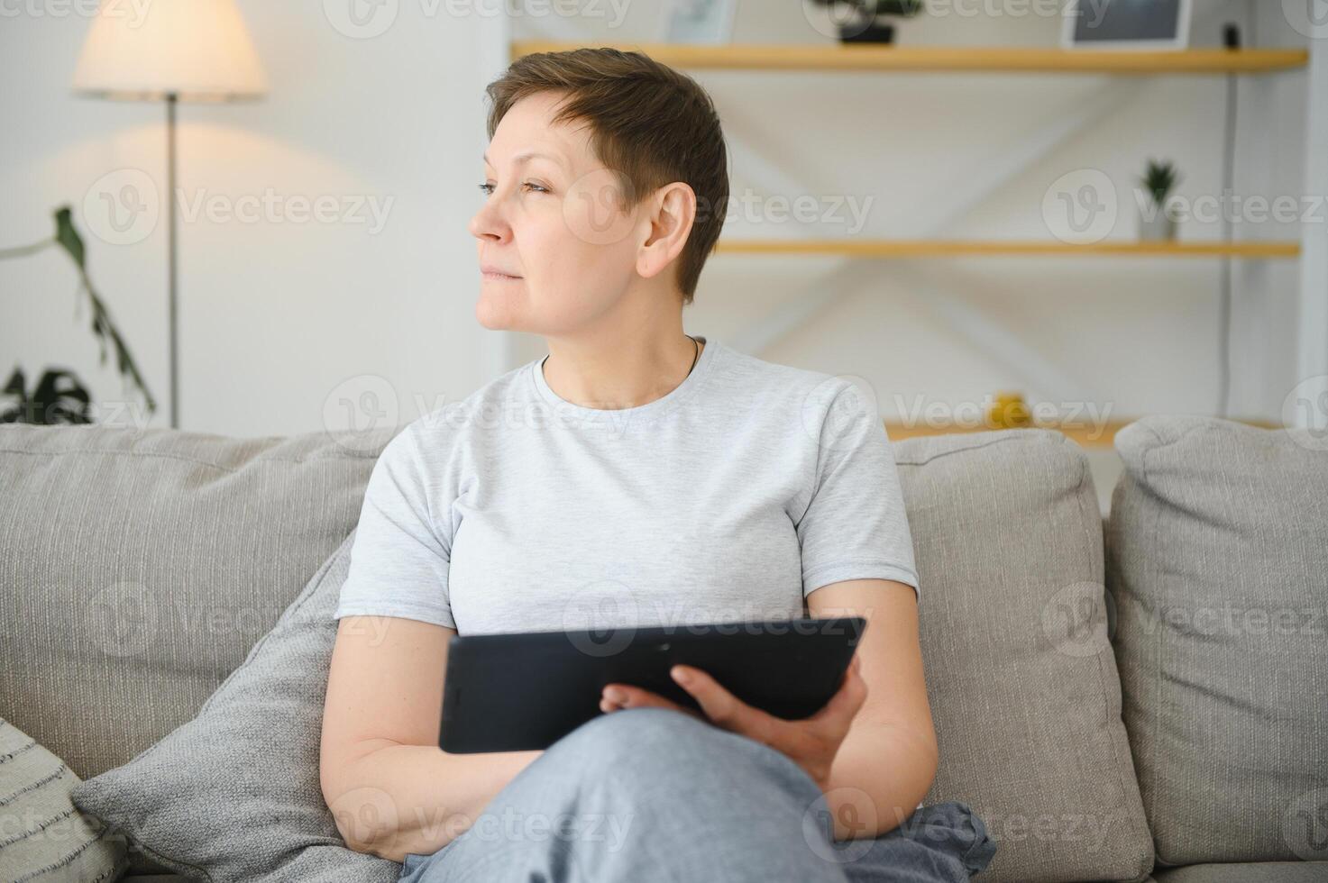people, technology and internet concept - happy middle aged woman with tablet pc computer at home. photo