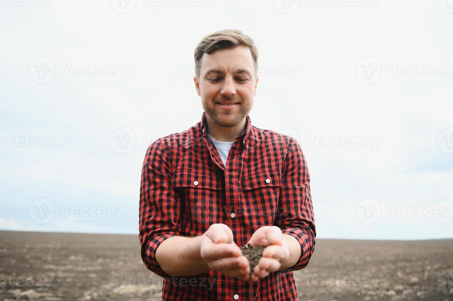 Farmer's hands hold a handful of fertile soil. The concept of agriculture, agribusiness. The gardener holds humus, fertilized soil, compost soil in his palms. Agriculture and fertility. photo