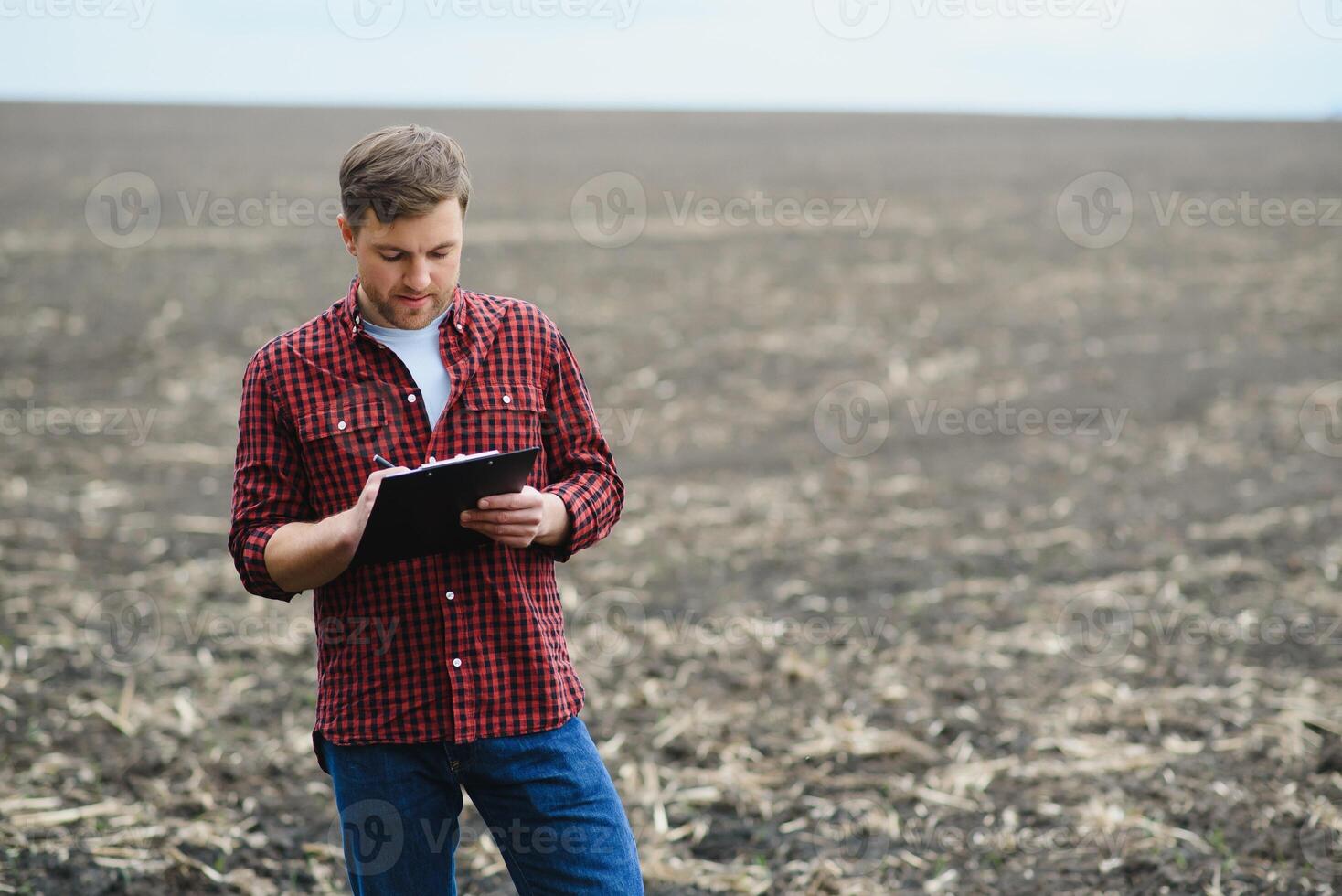 A farmer checks quality of soil before sowing. woman farmer with a tablet in field holds earth in his hands. girl agronomist checks the quality of sowing grain. business woman checks her field. photo