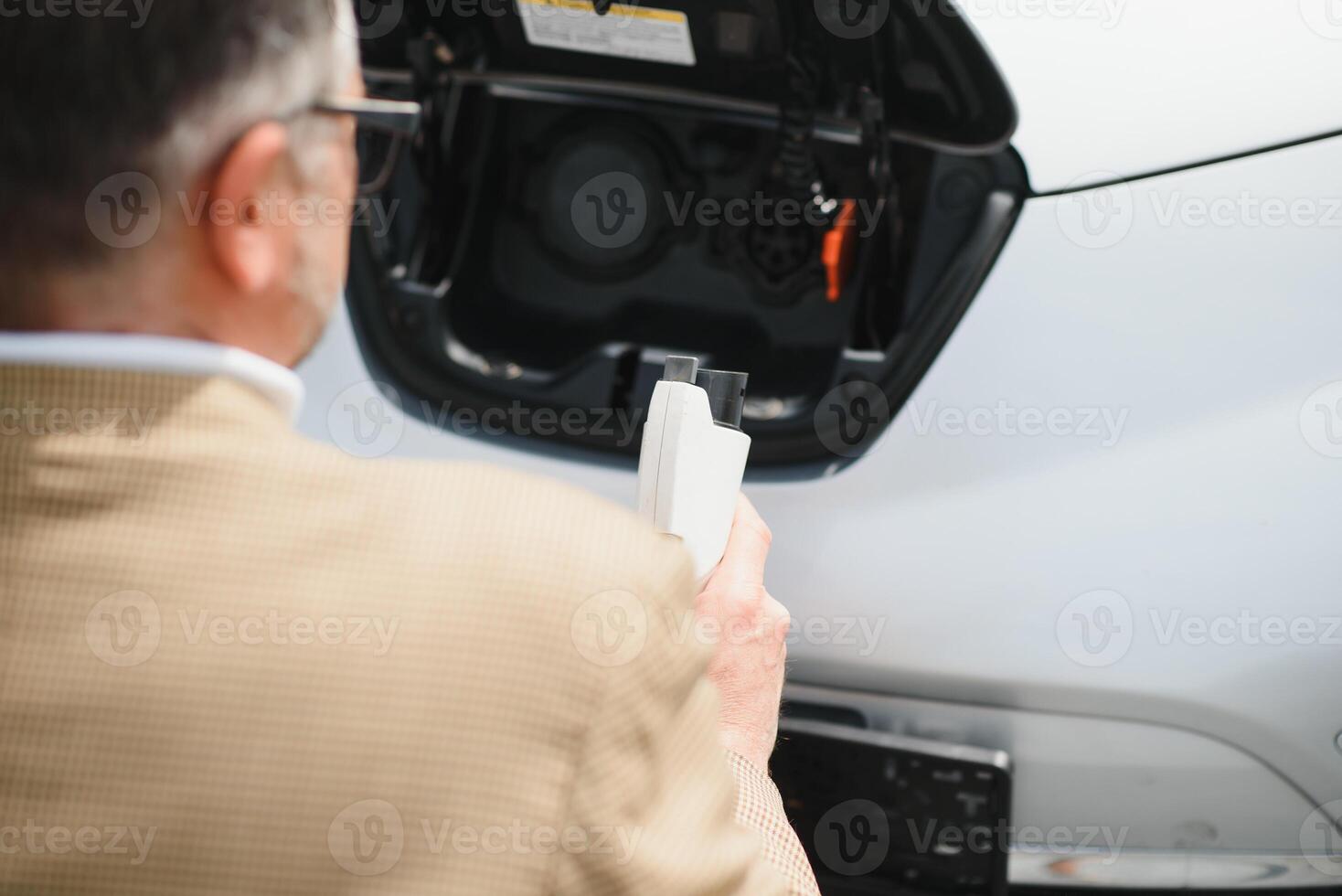 Man holding power connector for electric car photo