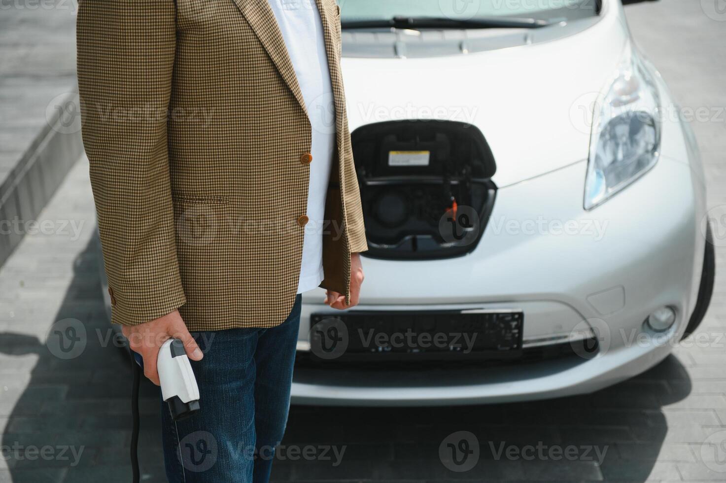 Man holding power connector for electric car photo