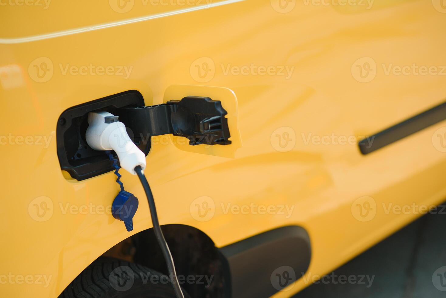 Hansome bearded guy near his new modern electric car at the charging station photo