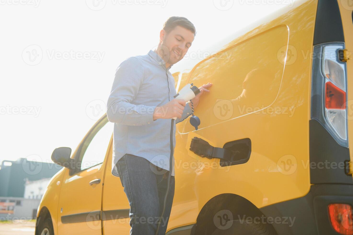 Man Charging Electric Vehicle With Cable photo