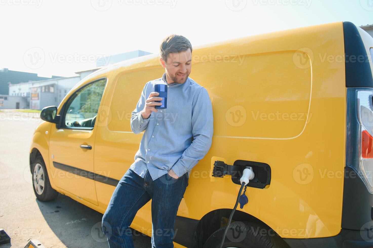 Man charges an electric car at the charging station. photo