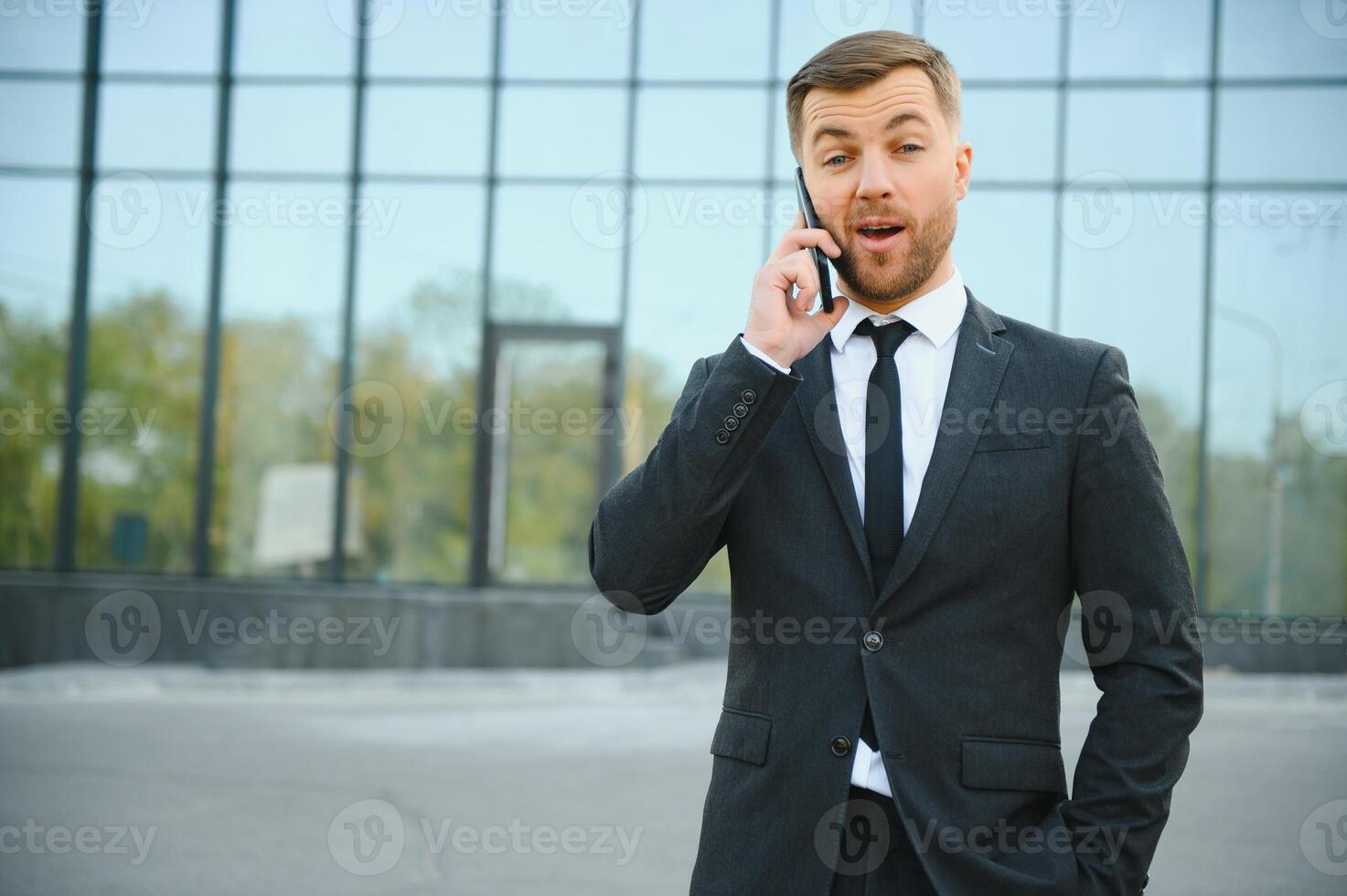 Businessman using smartphone in covered walkway. photo