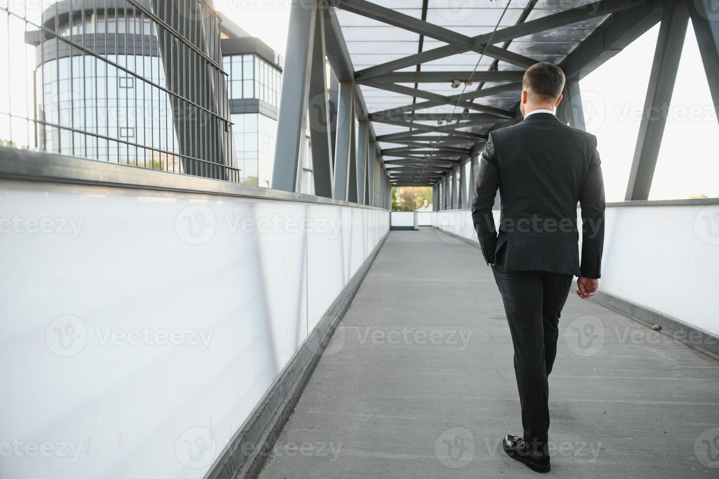 Stockbroker near the office. A successful and advanced handsome business man in a suit looks up in front of him standing on the background of concrete steps. photo