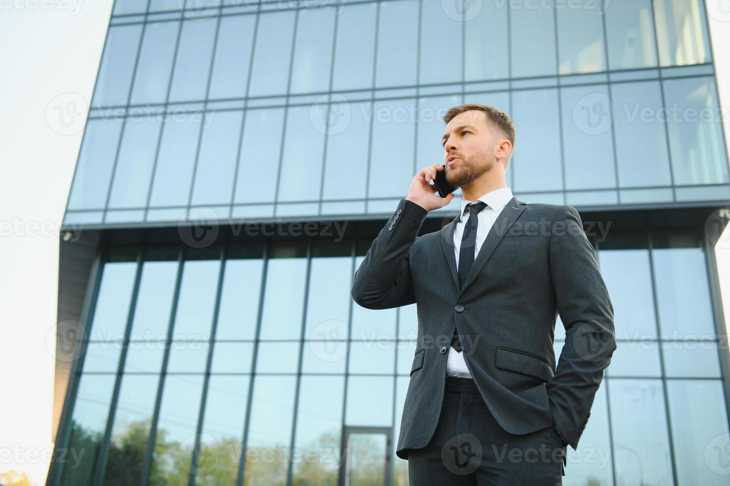 Businessman using smartphone in covered walkway. photo