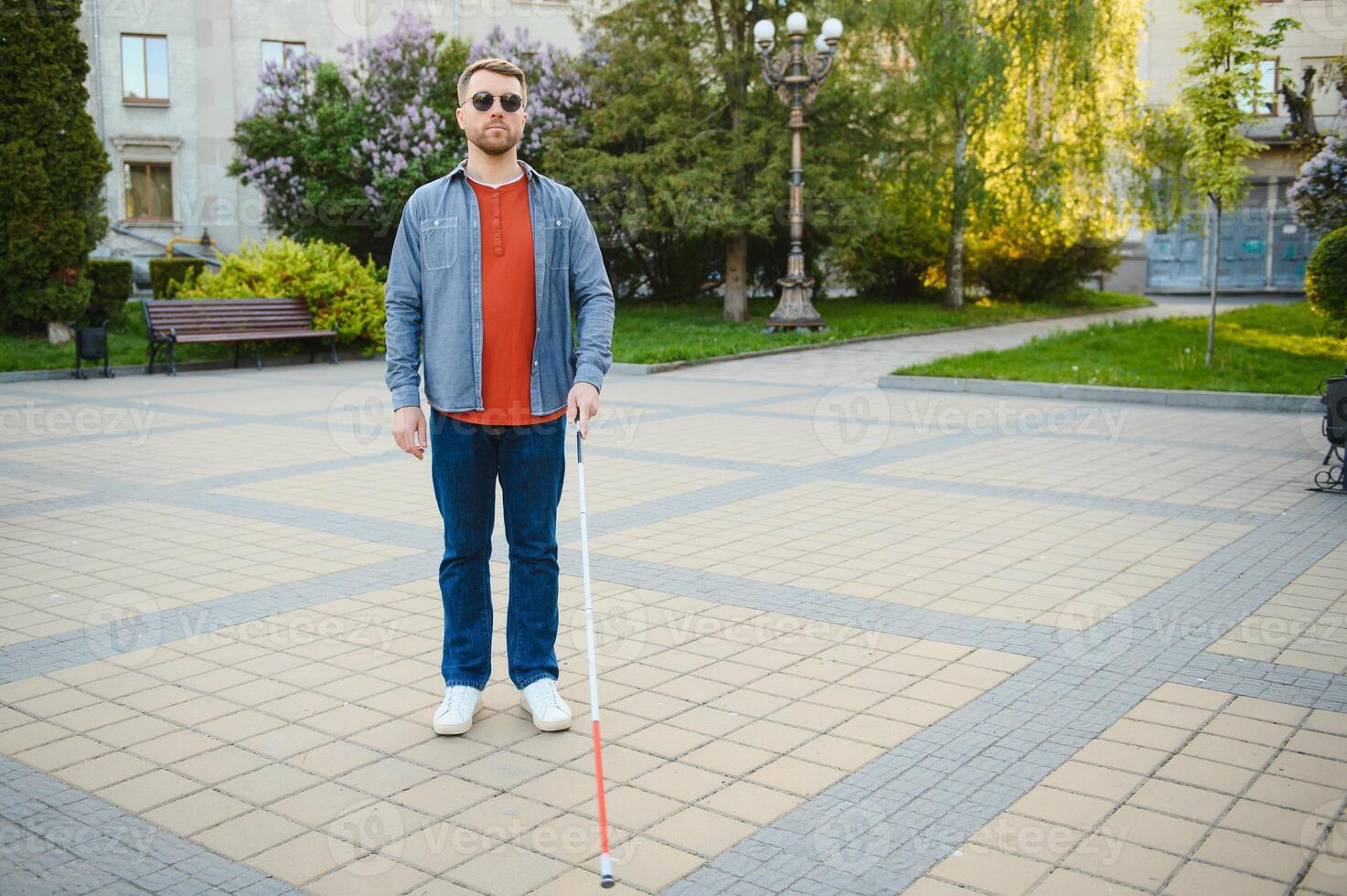 Close-up Of A Blind Man Standing With White Stick On Street photo