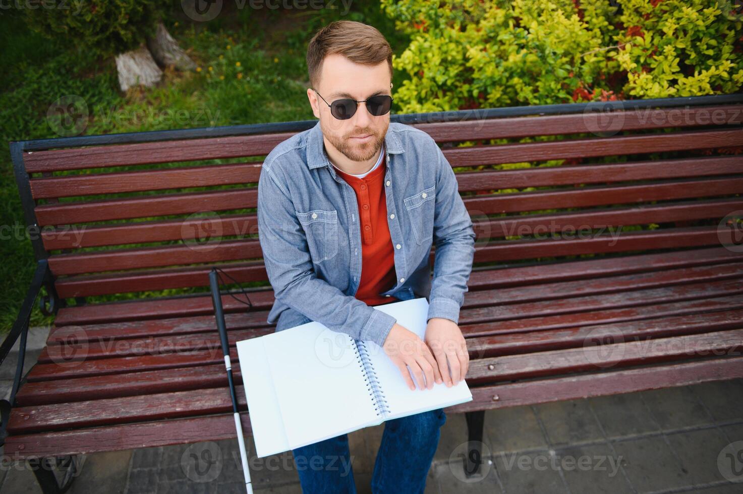 Blinded man reading by touching braille book photo