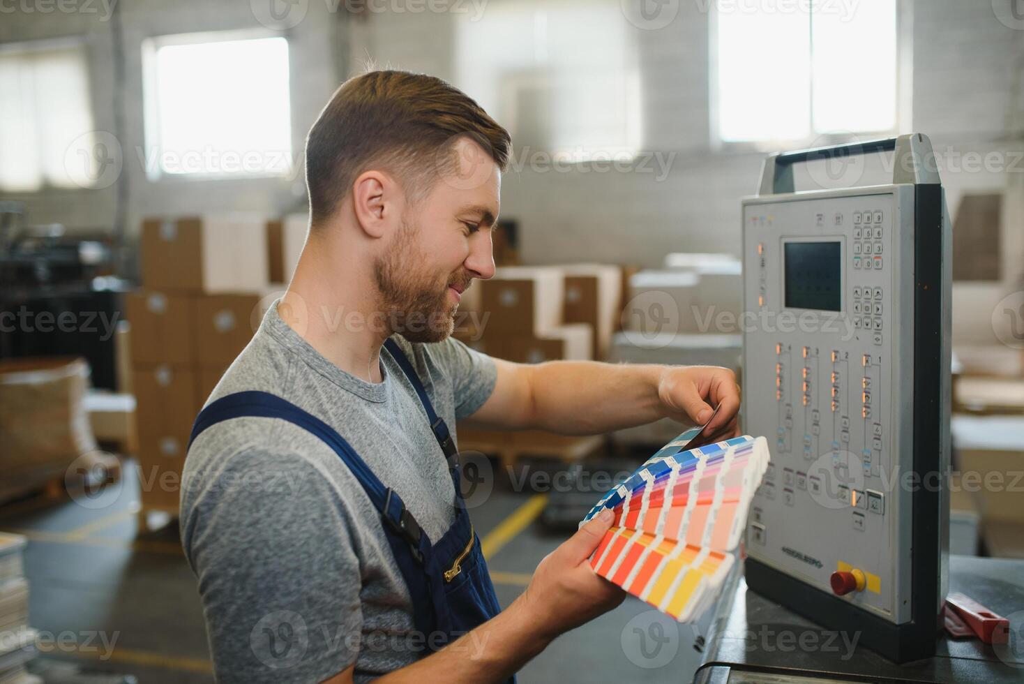 Funny portrait of typographer standing with color swatches at the printing manufacturing photo