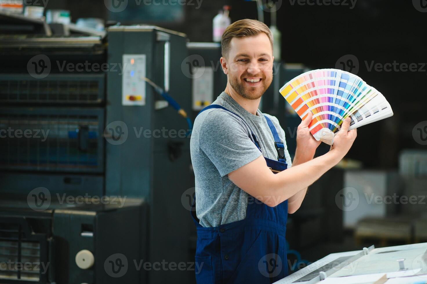 Funny portrait of typographer standing with color swatches at the printing manufacturing photo