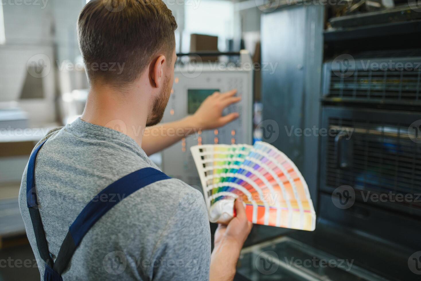 Funny portrait of typographer standing with color swatches at the printing manufacturing photo