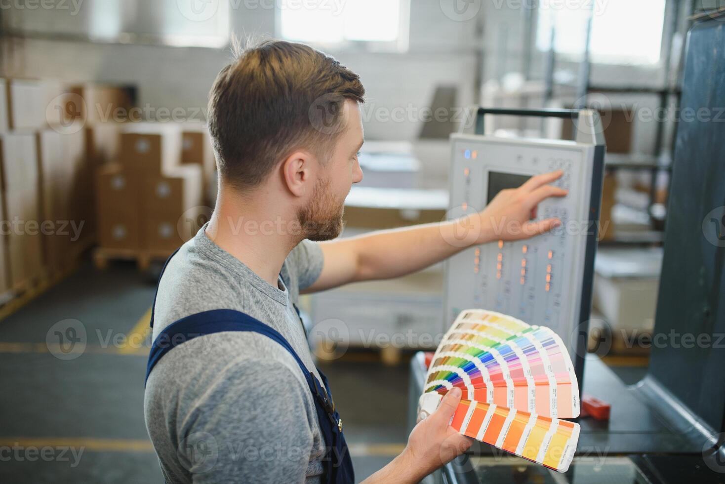 Funny portrait of typographer standing with color swatches at the printing manufacturing photo