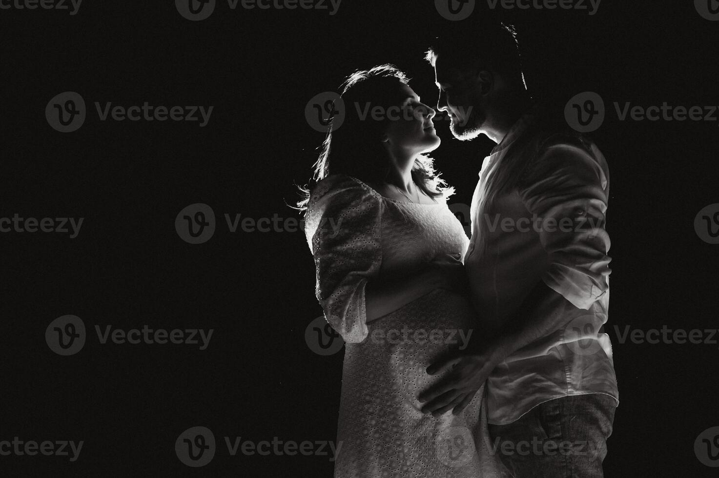 Happy Pregnant Couple. Mother and Father Love expecting Baby during Pregnancy. Family waiting Child Birth over Black night Background photo