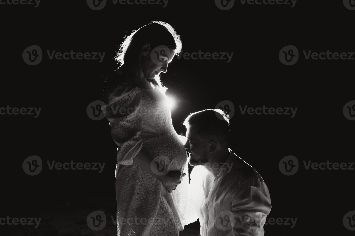 Happy Pregnant Couple. Mother and Father Love expecting Baby during Pregnancy. Family waiting Child Birth over Black night Background photo