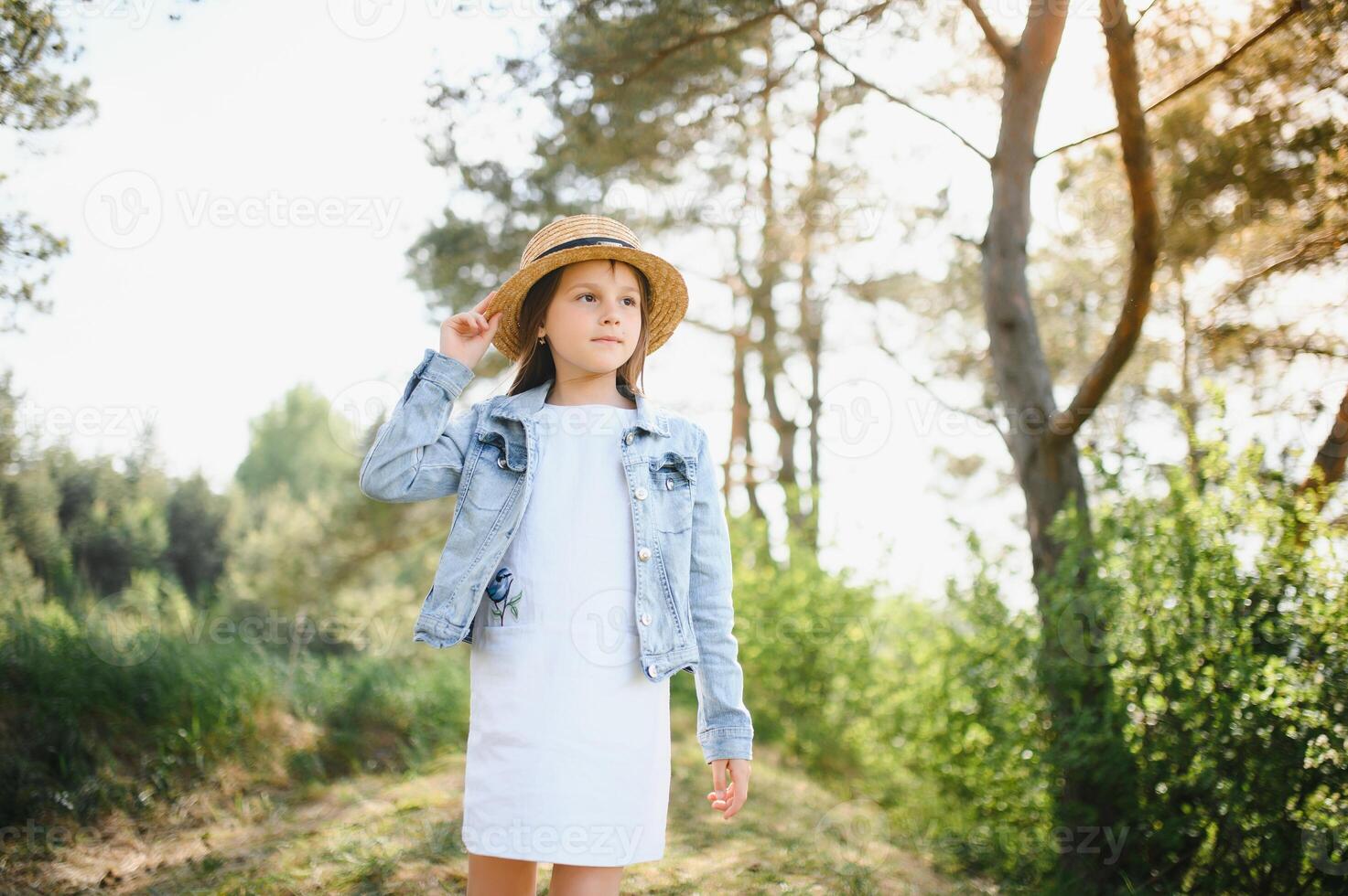 Funny cute child girl in park over nature background. Happiness. Summer season. photo