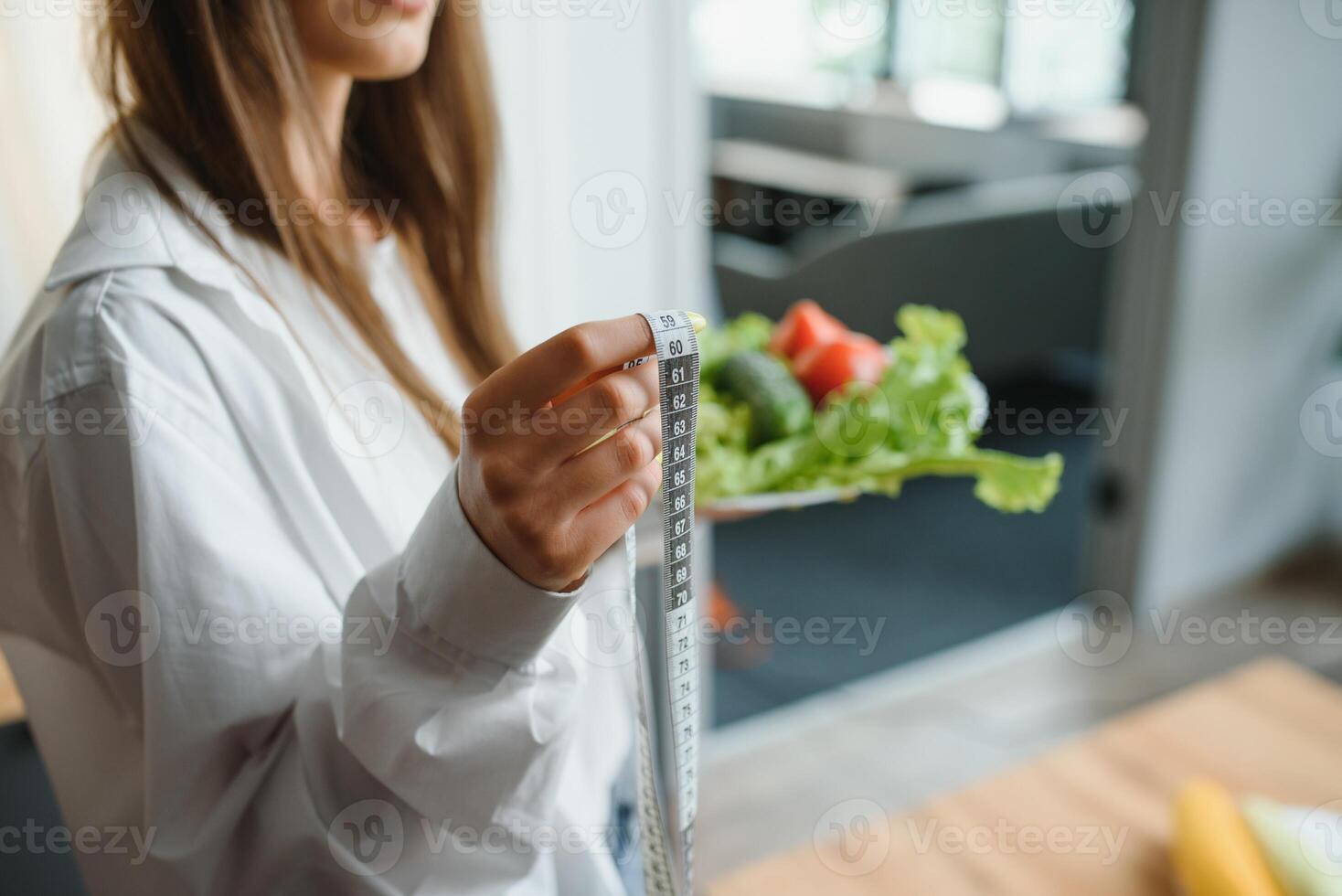 Beautiful woman cooking healthy food in the kitchen - indoors. Young Woman Cooking. Healthy Food - Vegetable Salad. Diet. Dieting Concept. Healthy Lifestyle. Cooking At Home. Prepare Food. photo