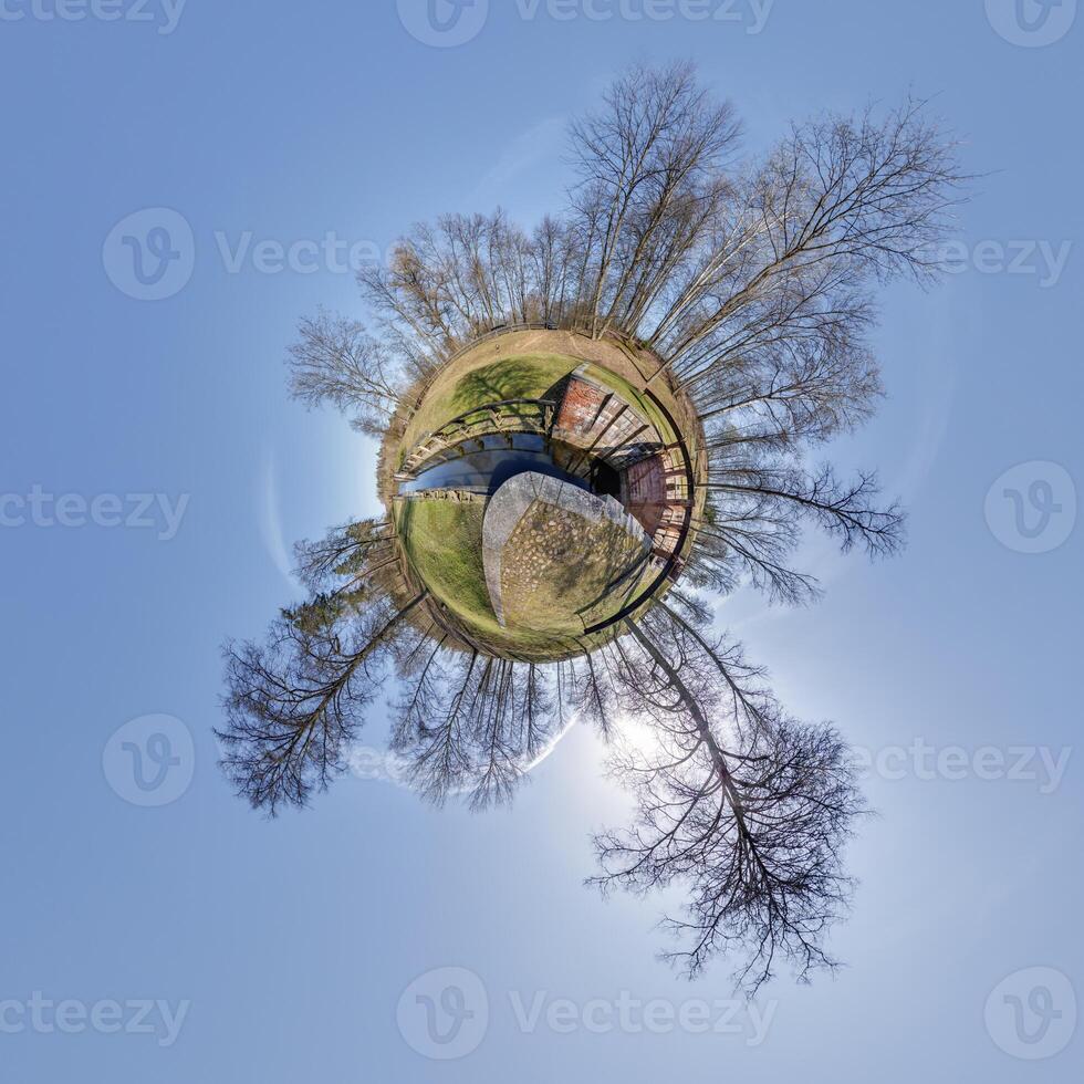 tiny planet transformation of spherical panorama 360 degrees. Spherical abstract aerial view with trees in forest with clumsy branches in blue sky. Curvature of space. photo