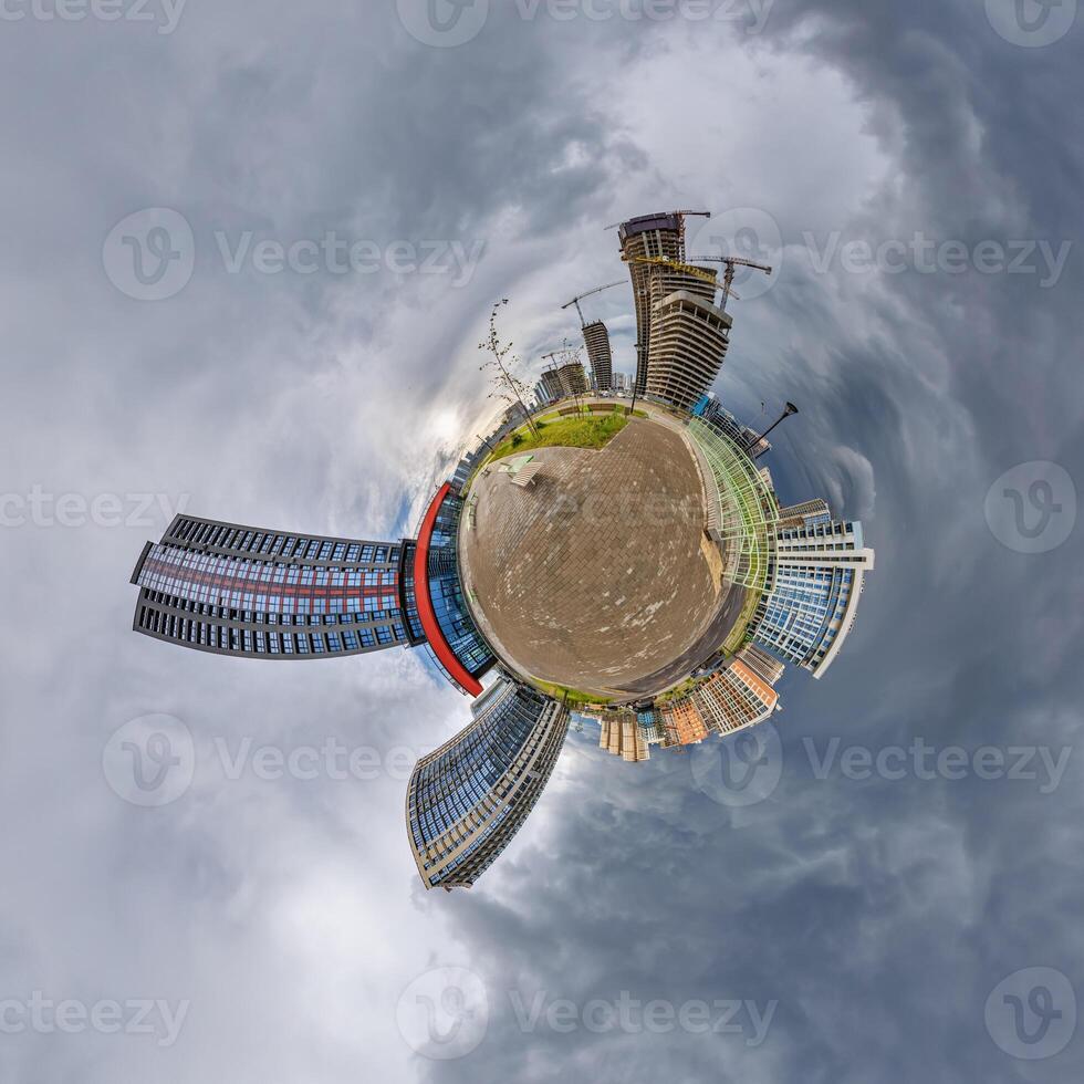 abstract swirling tiny planet spherical panorama of multi-storey buildings of skyscrapers of a residential complex in the form of a butterfly, bugs, crabs in sky with clouds photo